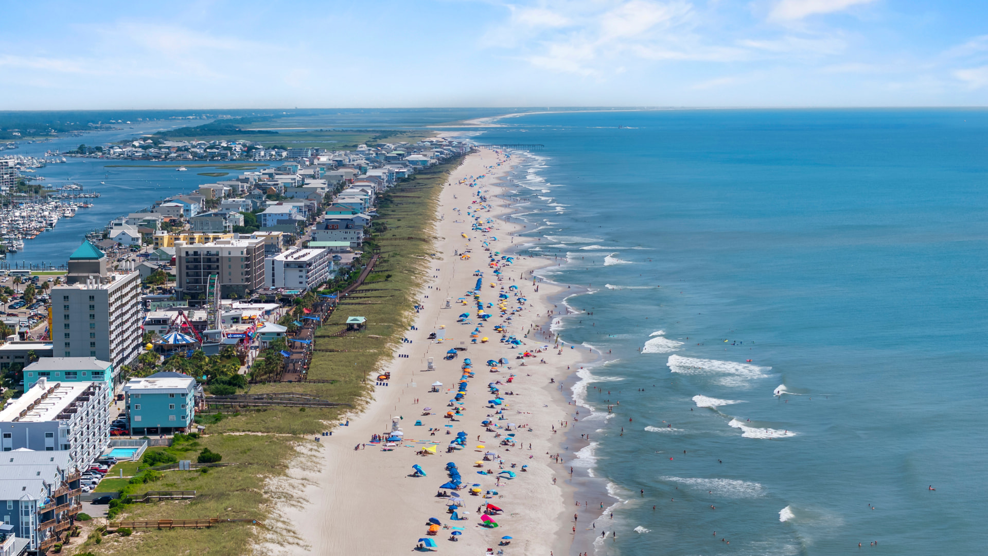 Aerial view of the Carolina Beach shoreline, boardwalk, marina, and pier