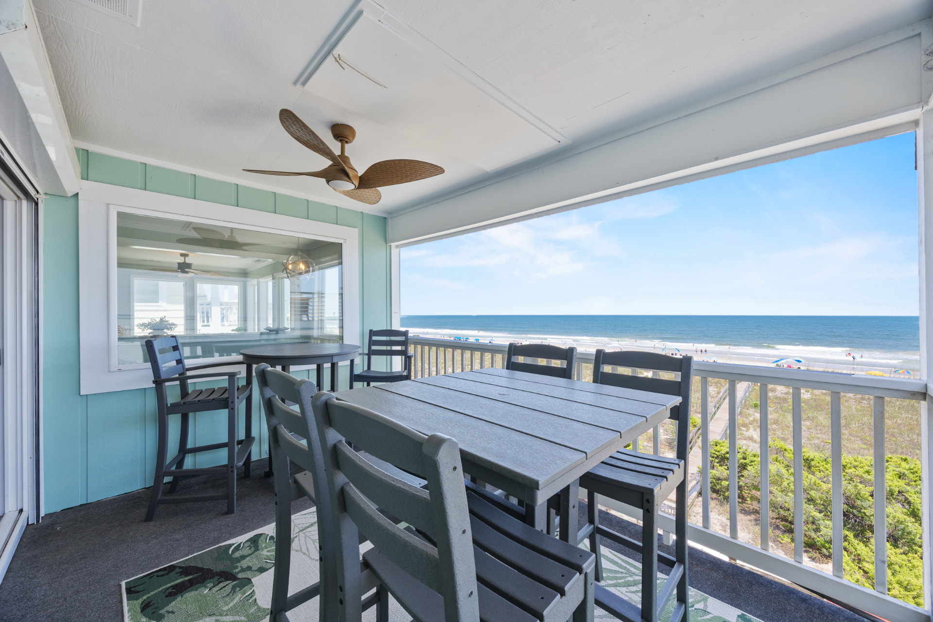 The covered oceanfront balcony with a full table and chairs facing the water