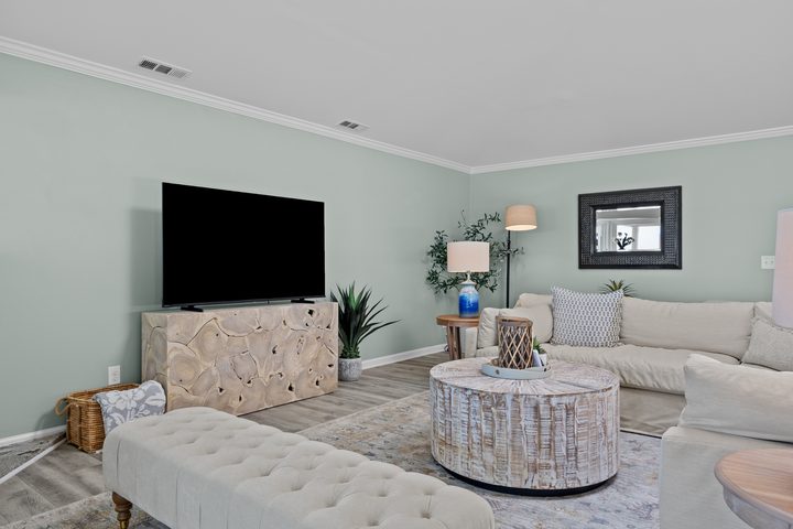 Living room with round wood coffee table and coastal art
